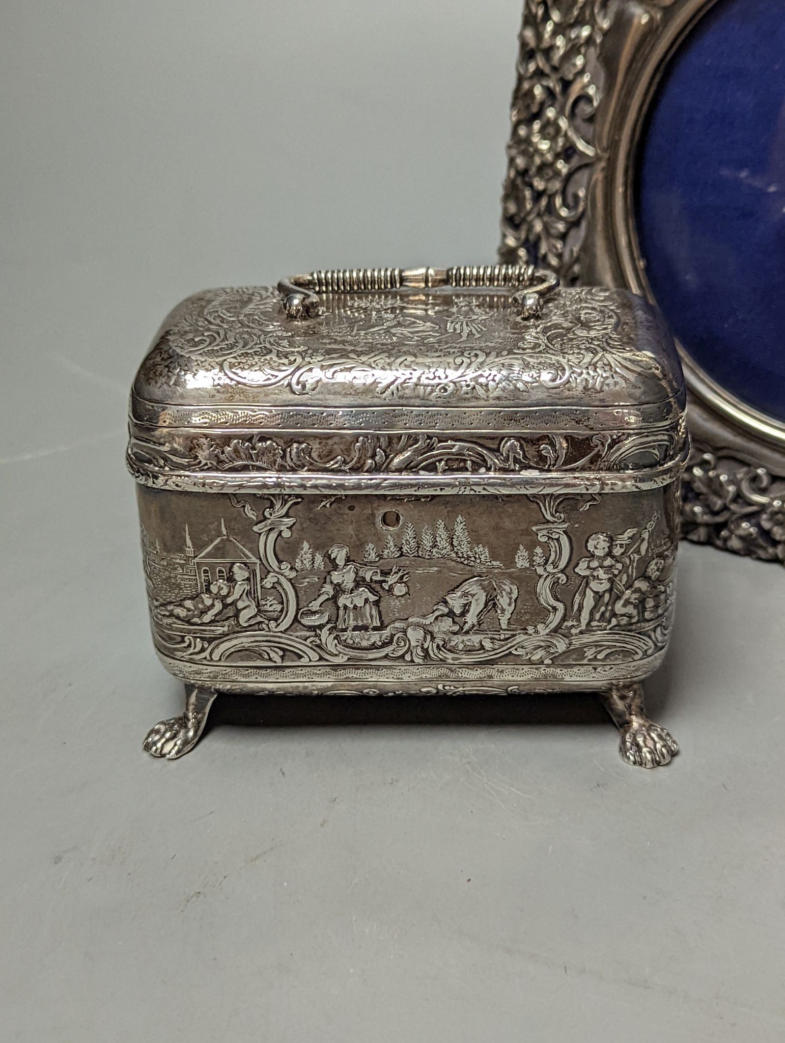 An Edwardian repousse silver mounted photograph frame, Birmingham, 1901, 15.8cm and a small white metal casket.